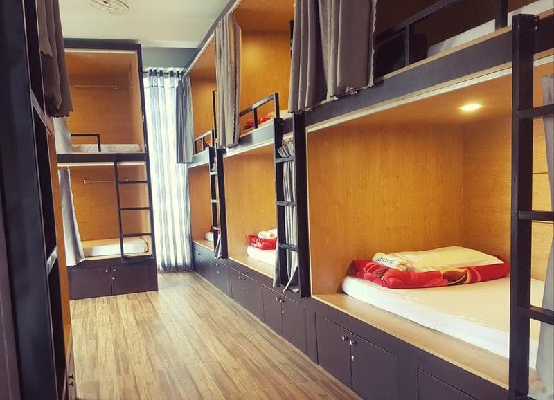 Wooden capsule bunks with privacy curtains in the Mooka's Home dorm